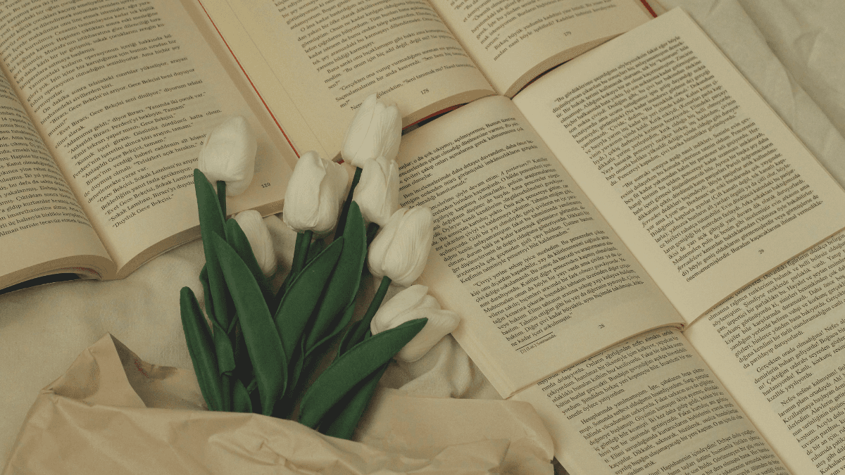 Open books and flowers arranged on a table